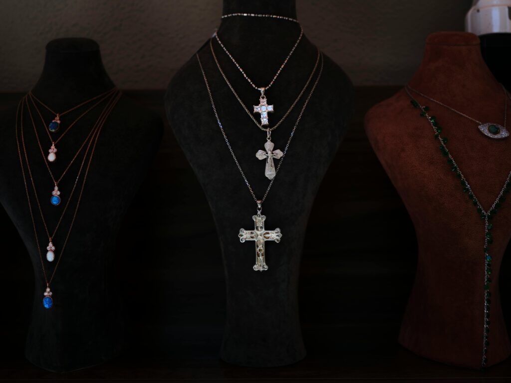 Showcase of elegant cross necklaces on velvet display busts. Perfect for religious and jewelry themes.
